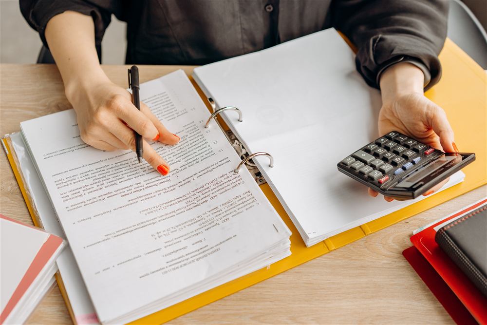 Bookkeeper reconciling financial records with a calculator